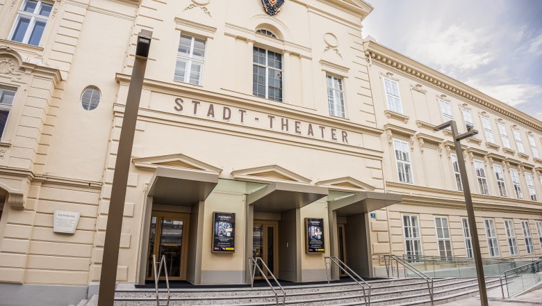 Stadttheater Wiener Neustadt: Neue Türen zu kultureller Vielfalt, © Alex Schwarz Photography Fassade des Stadttheaters Wiener Neustadt mit historischer Architektur, drei Eingängen und moderner Glasrampe