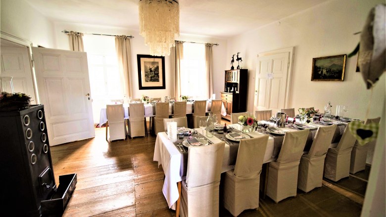 Celebrating in the Vienna Alps, © Gluschitz-Goebel Elegant dining room with table setting and chandelier.