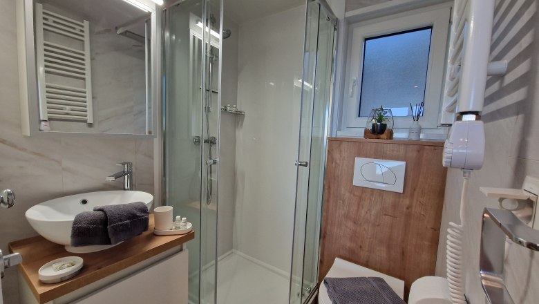 Badezimmer 1 Johannesbachklamm Chalet, © Johannesbachklamm Chalet Modernes Badezimmer mit Dusche, Waschbecken und Toilette.