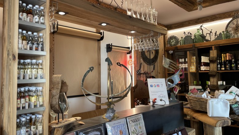 Dekostadl Pernitz, © Wiener Alpen/Katharina Lechner Innenansicht eines rustikalen Ladens mit Spirituosen, Gläsern und Dekorationsartikeln.