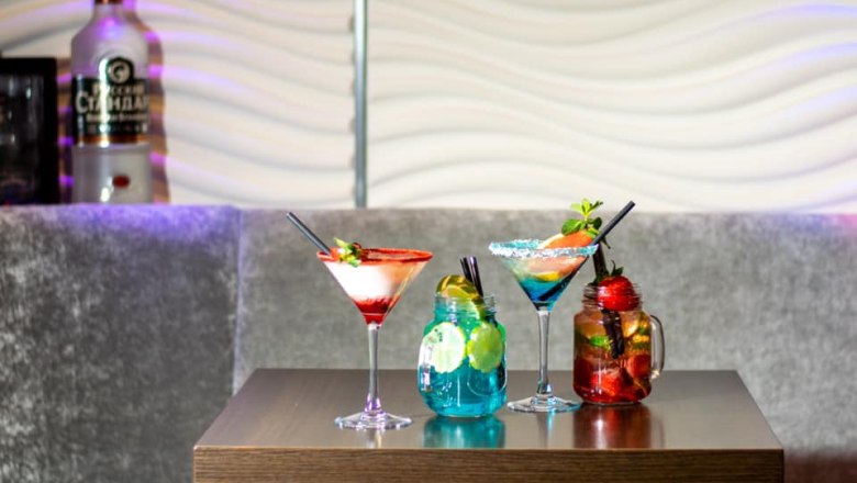 Cocktails, © Elit Facebook Drei bunte Cocktails auf einem Tisch in einer Bar.