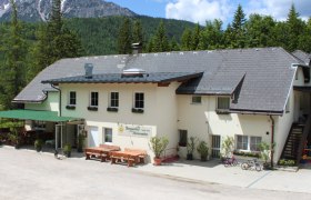 Berggasthof Mamauwiese, © Berggasthof Mamauwiese, Bernhard Wilsch Berggasthof Mamauwiese vor bewaldeten Bergen.