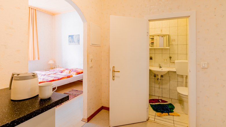 Ferienwohnung, © Wiener Alpen / Christian Kremsl Innenansicht einer Ferienwohnung mit Blick auf Schlafzimmer und Badezimmer.