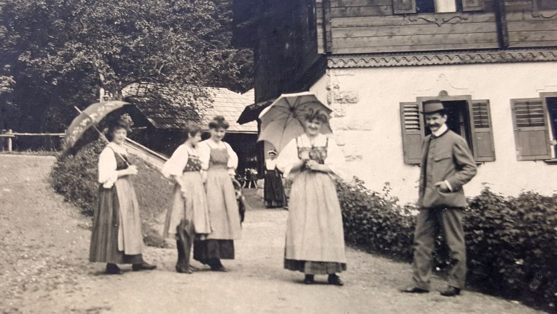Riegelhof historical, © Riegelhof Black and white picture with women in long dresses and on the right a man in a hunting suit and hat