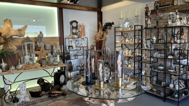 Dekostadl Pernitz, © Wiener Alpen/Katharina Lechner Innenansicht eines Dekorationsladens mit Regalen voller Dekoartikel und einem Tisch mit Glasplatte.