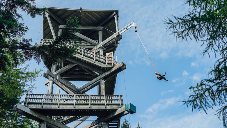 Millennium Jump am Hirschenkogel, © Semmering Hirschenkogel Bergbahnen GmbH Person springt mit einem Seil von einer Aussichtswarte.