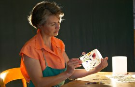 Schlögl Erlesenes, © Schlögl, Fotograf: Franz Zwickl Frau dekoriert eine Laterne mit gepressten Blumen.