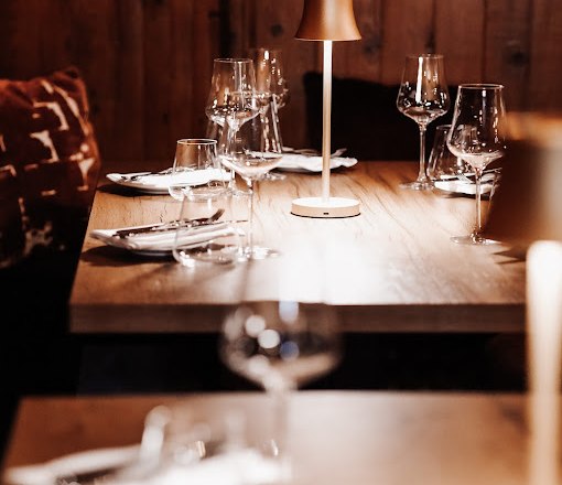 Mädchen und Wolf, © Mädchen und Wolf Eleganter Restauranttisch mit Weingläsern und Tischlampe.