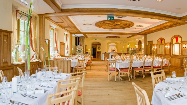 Speisesaal, © Schubertlinde Eleganter Speisesaal mit gedeckten Tischen und Holzverkleidung.