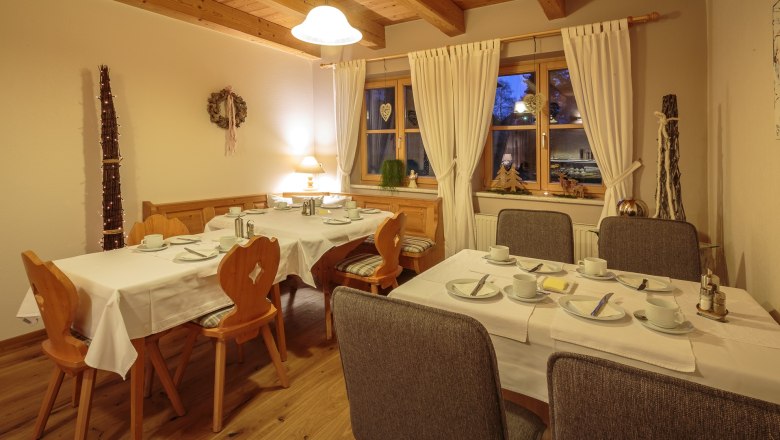 Früshtücksraum, © rosinger Gemütlicher Frühstücksraum mit gedeckten Tischen, Holzmöbeln und Dekorationen.