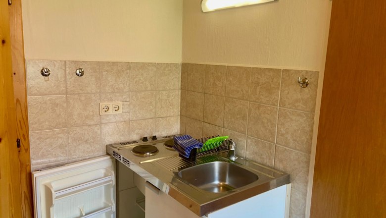 Küchennische, © Wiener Alpen Kleine Küchennische mit Spüle, Herd und Kühlschrank.