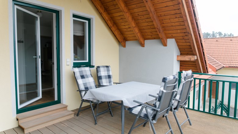 Großzügige Dachterrasse, © heiter-weiter.at/Karl Stangl Dachterrasse mit Tisch und Stühlen unter einem Holzdach.