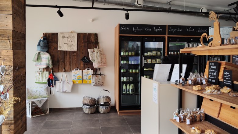 Eingang Dorfladen Lichtenegg, © Wiener Alpen Innenansicht eines Dorfladens mit Regalen voller Produkte und Dekorationen.