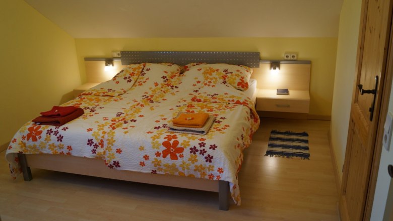 Ahornzimmer mit eigenem Sanitär, © Reep Gemütliches Schlafzimmer mit Doppelbett und Blumenbettwäsche.