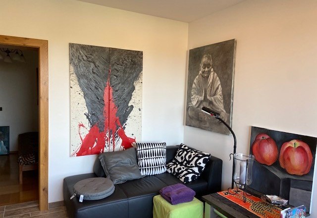 Cozy corner, © Wiener Alpen Living room with artwork on the walls, black sofa and colorful cushions.