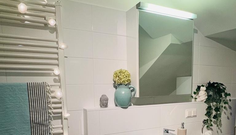 Badezimmer, © Martina Lechner Modernes Badezimmer mit Waschbecken, Spiegel, Handtuchhalter und Dekorationen.