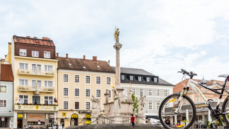 Hotel Zentral, © Wiener Alpen / Martin Fülöp Stadtplatz mit Brunnen, Fahrrad im Vordergrund, Hotel Zentral im Hintergrund.