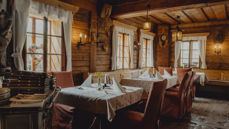 Bauernhaus aus dem Jahr 1666, © Niederösterreich Werbung/Rita Newman Innenansicht eines rustikalen Restaurants mit Holzwänden und gedeckten Tischen.