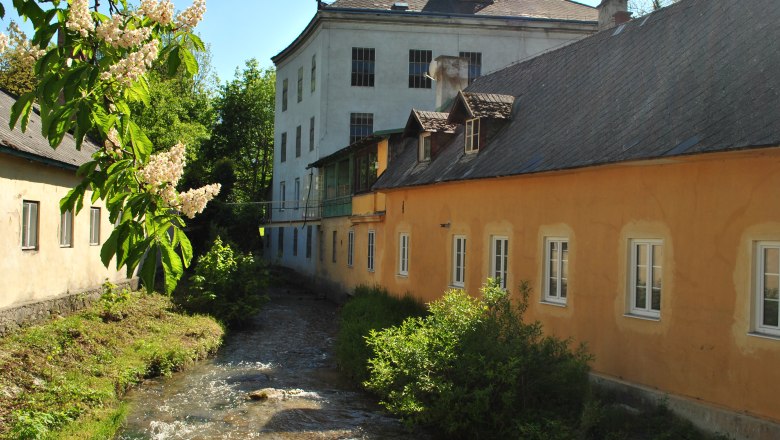Bread and Mill Museum, © Brot- und Muehlenmuseum Historic building with stream and blossoming tree in the foreground.