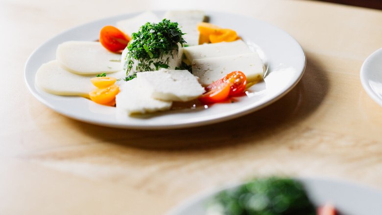 Kulinarische Reise, Schafkäse, Althammerhof, Semmering, Wiener Alpen, © Niederösterreich Werbung/Mara Hohla Herunterladen Ein köstlicher Teller mit frisch zubereitetem Schafkäse, garniert mit frischen Kräutern und buntem Gemüse, lädt zum Genießen ein. Die harmonische Kombination aus Aromen und Farben verspricht ein unvergessliches Geschmackserlebnis inmitten der malerischen Landschaft der Wiener Alpen.