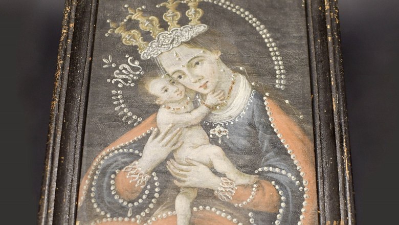 Traces of faith in Neunkirchen, © Hannes Schiel An old painting in a worn wooden frame shows a crowned woman with a child in her arms.