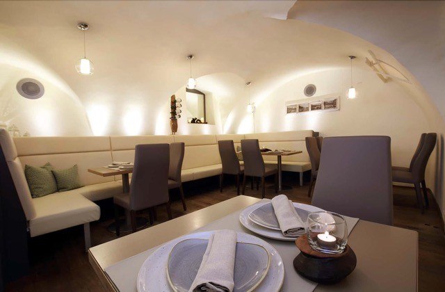 S Platzl dining room, © Schilowsky_NM_©redtenbacher Elegant dining room with vaulted ceiling, modern furniture and table setting.