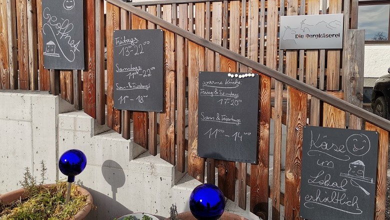 Eingang zur Bergkäserei, © Wiener Alpen Eingang zur Bergkäserei mit Schildern und blauen Kugeln.