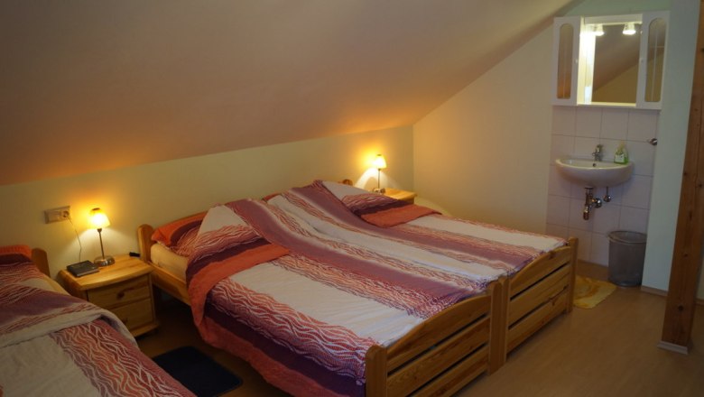 Fichtenzimmer mit 3-4 Betten, © Reep Zimmer mit drei Betten, Nachttischen, Lampen und Waschbecken.