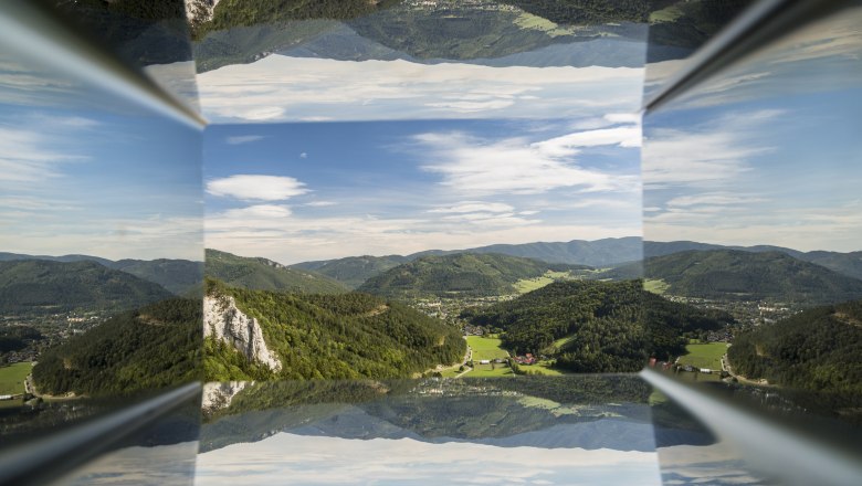 Blickplatz Hausstein, © Wiener Alpen, Foto: Franz Zwickl Spiegelung einer Berglandschaft mit blauem Himmel und Wolken.