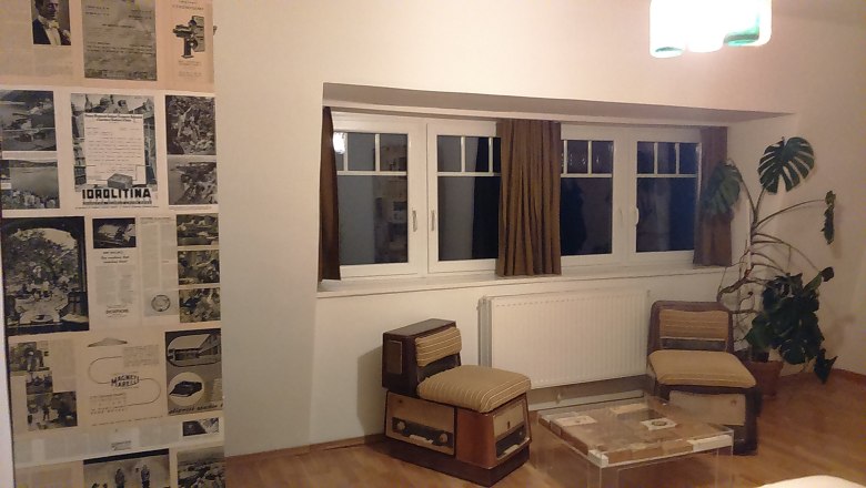 Rooms at Hotel Binder, © Wiener Alpen Hotel room with retro furniture, newspaper wall and large plant.