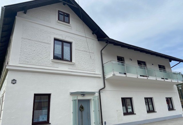 Privaztzimmer Cornelia Strasser, © Wiener Alpen Zweistöckiges weißes Haus mit Balkon und mehreren Fenstern.