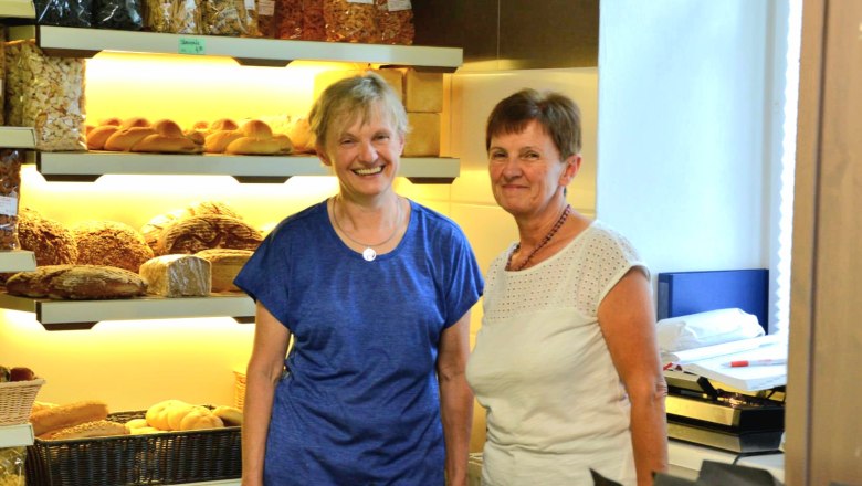 Renate Maschler & Team, © Gemeinde Schwarzenbach Zwei Frauen in einer Bäckerei vor Regalen mit Brot und Gebäck.