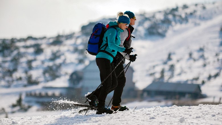 Naturabenteuer auf der Rax, © Wiener Alpen/Kremsl Zwei Personen beim Schneeschuhwandern auf einem verschneiten Berg.