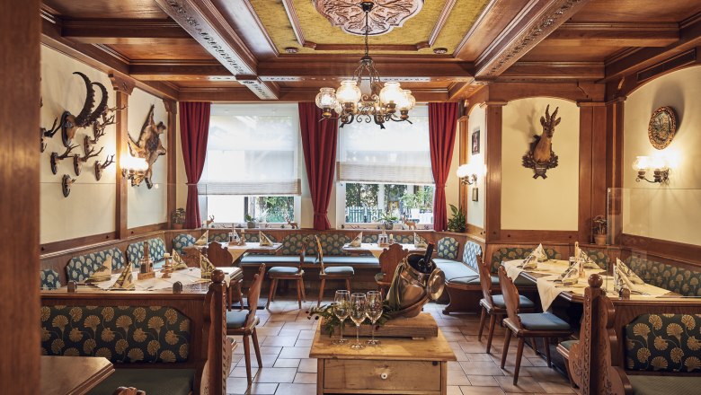 Jägerstube, © Niederösterreich Werbung/Andreas Hofer Gemütliche Jägerstube mit Holzmöbeln, Jagdtrophäen an den Wänden und gedeckten Tischen.