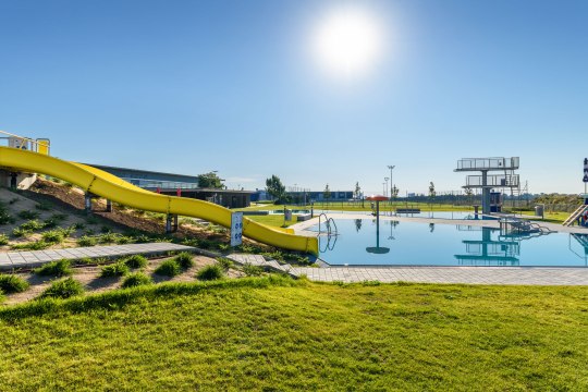 Badespaß in der Aqua Nova, © Wiener Alpen/Schubert Ein Freibad mit einer gelben Rutsche ist zu sehen