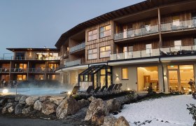 Winterstimmung mit Außenpool, © Peter Pichler Hotelgebäude mit Außenpool und Schnee im Vordergrund.