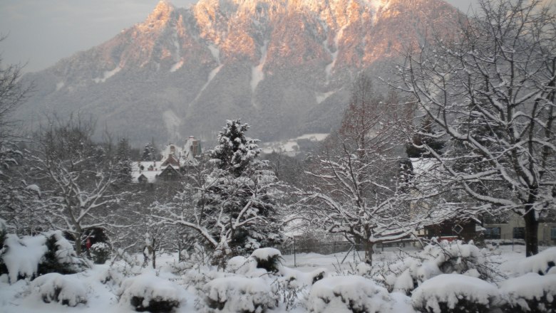 Winter beim Flackl-Wirt, © Flackl-Wirt Verschneite Landschaft mit Bergen im Hintergrund, beleuchtet von der Abendsonne.