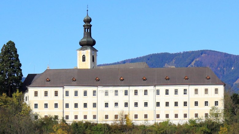 Schloss Gloggnitz, © BWAG Schloss Gloggnitz vor bewaldeten Hügeln und blauem Himmel.