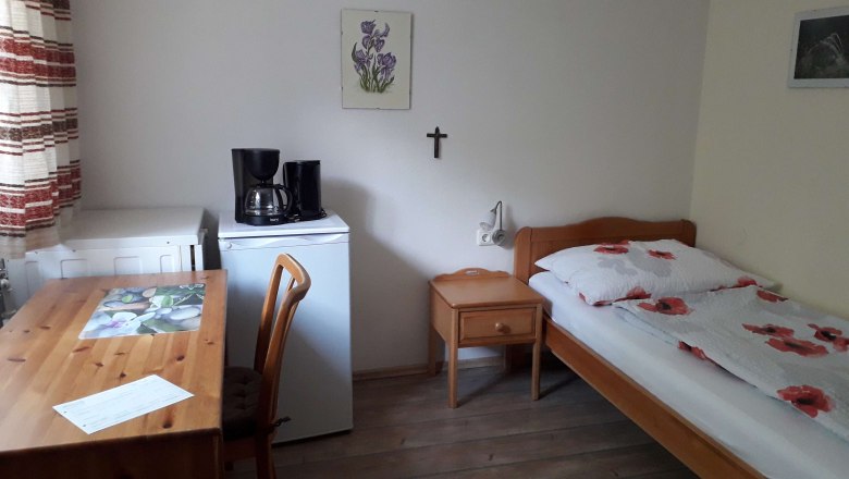 Zimmer mit Küche, © Familie Laaber Ein einfach eingerichtetes Zimmer mit Bett, Tisch, Stuhl, Kühlschrank und Kaffeemaschine.