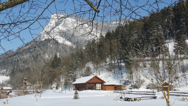Naturpark Falkenstein, © Marktgemeinde Schwarzau im Gebirge Verschneite Landschaft im Naturpark Falkenstein mit Holzhütte und schneebedecktem Berg im Hintergrund.