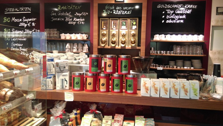 Coffee roastery Goldschmidt, © Kaffeerösterei Goldschmidt Interior view of a coffee roastery with coffee cans, cups and signs with coffee varieties.