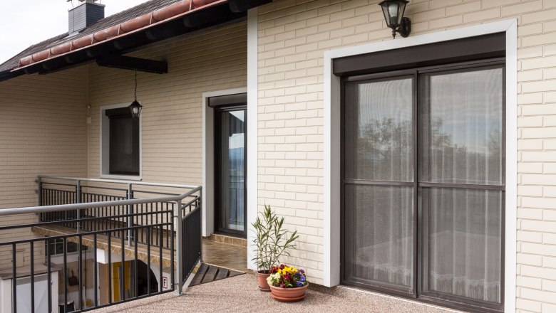 Außenansicht, © Fam. Sulzbacher Außenansicht eines Hauses mit Balkon, Blumen und Lampe.