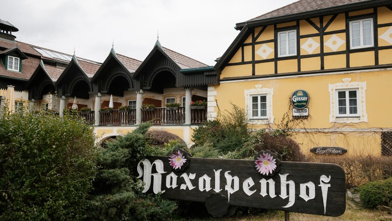 Raxalpenhof, © Sophie Menegaldo Ein traditionelles Gebäude mit gelber Fassade und einem Schild mit der Aufschrift 'Raxalpenhof'.