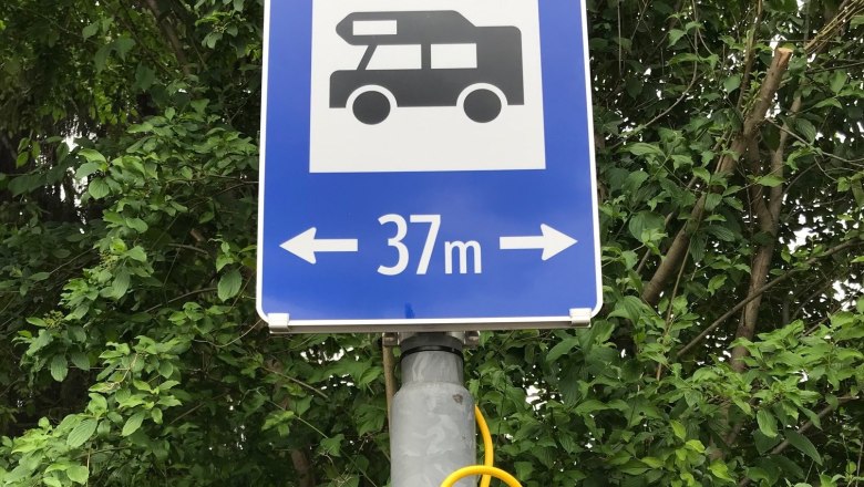 37 m Breite, © Birgit Rada-Tomasin Ein blaues Verkehrsschild mit einem Wohnmobil-Symbol und der Aufschrift '37 m' mit Pfeilen nach links und rechts.