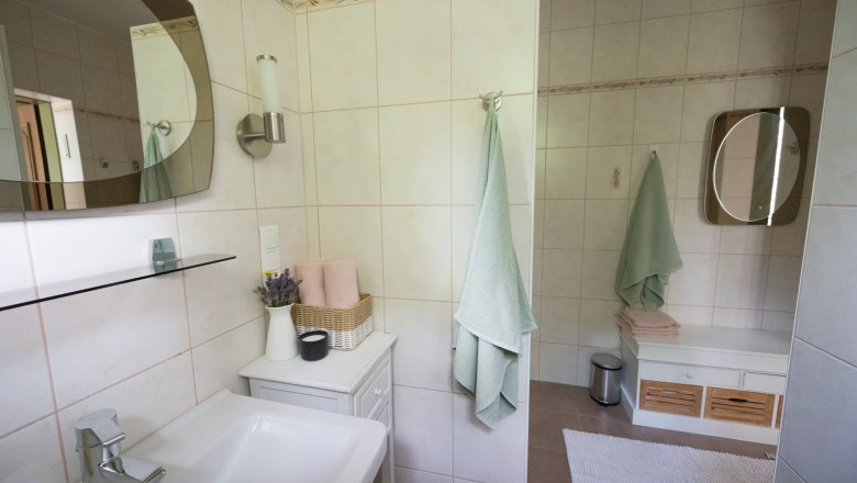 Badezimmer - Ferienhaus Schlager, © Claudia Schlager Modernes Badezimmer mit Waschbecken, Spiegel, Handtüchern und Dekoration.