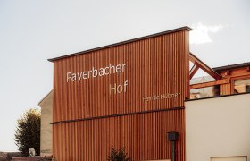 Payerbacherhof, © Payerbacherhof - Christopher Tarkus Holzfassade des Payerbacherhofs mit Schriftzug.