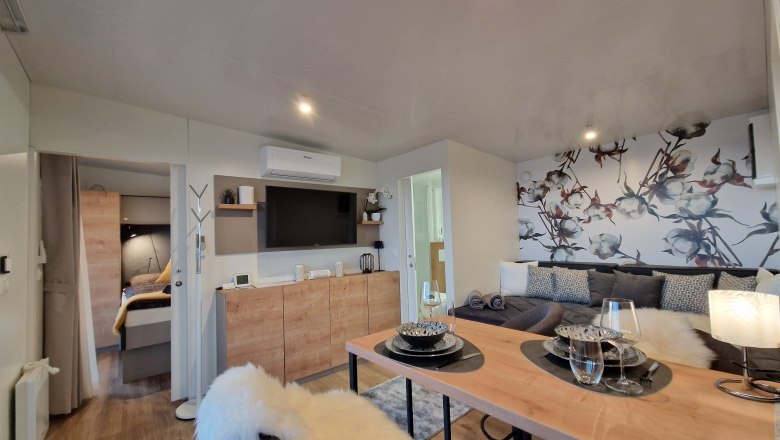 Wohnzimmer Johannesbachklamm Chalet, © Johannesbachklamm Chalet Modernes Wohnzimmer mit Esstisch, Sofa und dekorativer Wand.