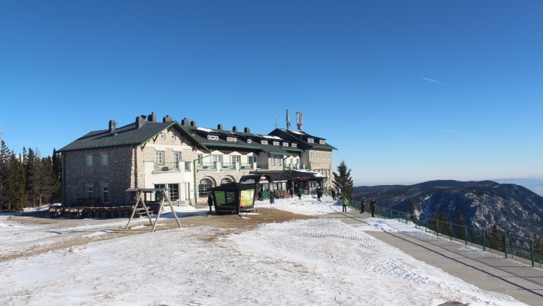 Raxalm Berggasthof in winter, © Scharfegger´s Raxalpen Resort Raxalm Berggasthof in winter with snow-covered ground and blue sky.