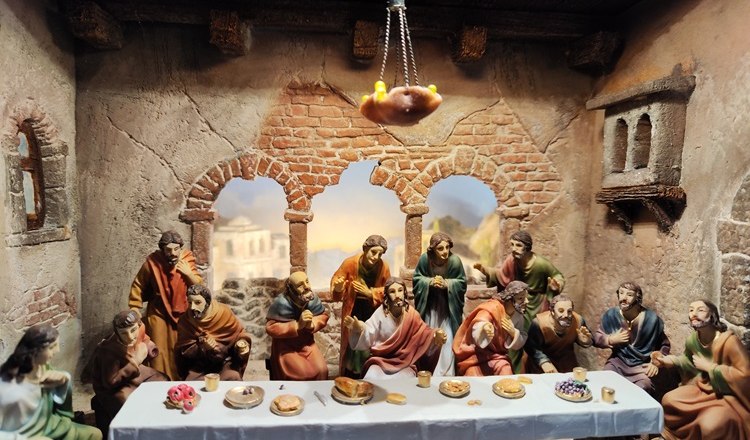 Szene einer Passionskrippe: das letzte Abendmahl, © Wiener Alpen Passionskrippe mit Figuren beim letzten Abendmahl in einem rustikalen Raum.