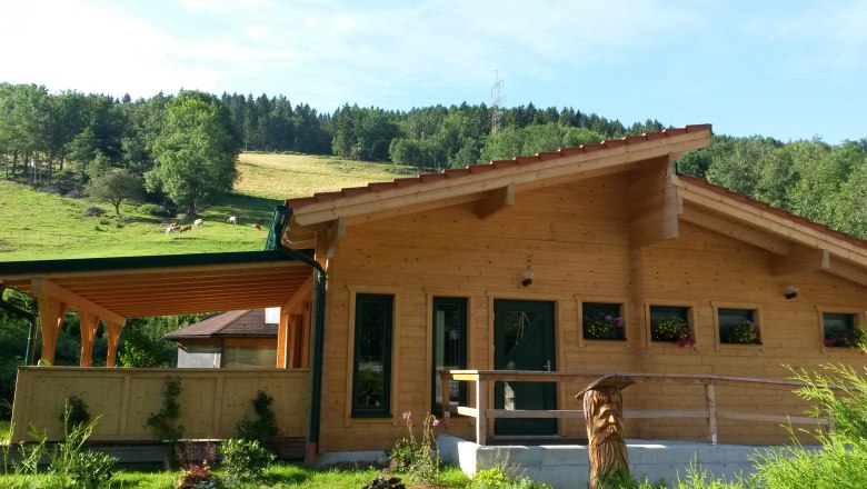 Blockhaussauna, © Familie Mies Blockhaussauna in ländlicher Umgebung mit Holzveranda und Blumenkästen.